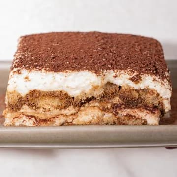 A slice of tiramisu dusted with cocoa