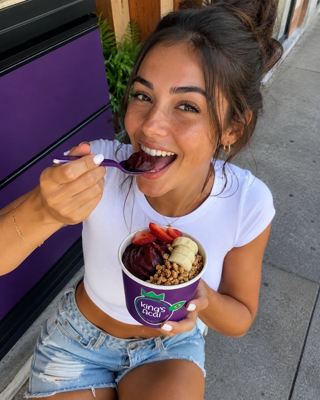 A woman smiling with a King’s Acai bowl