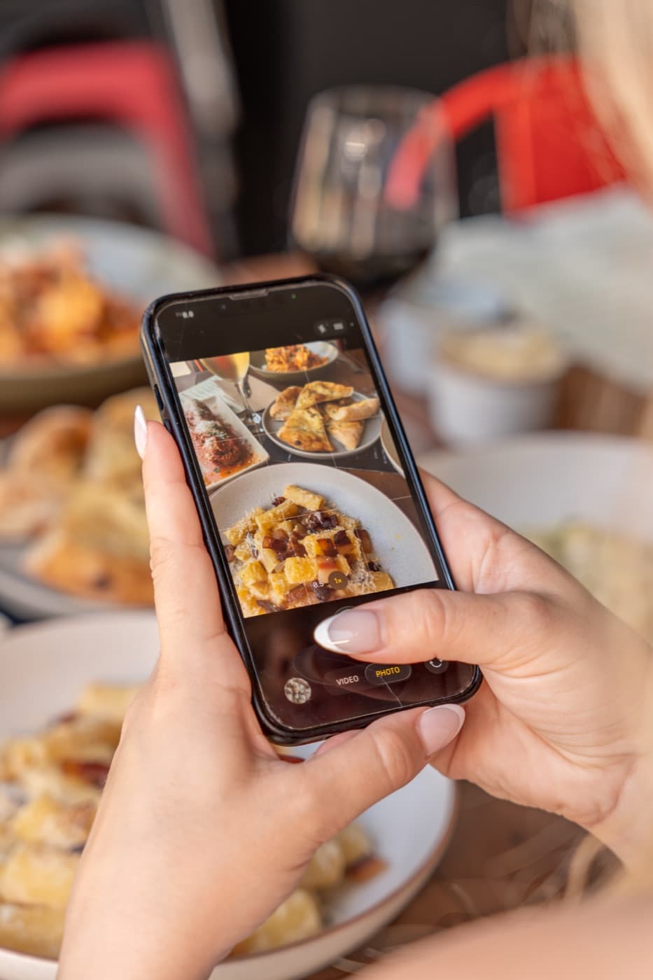 A phone photographing a plate of pasta