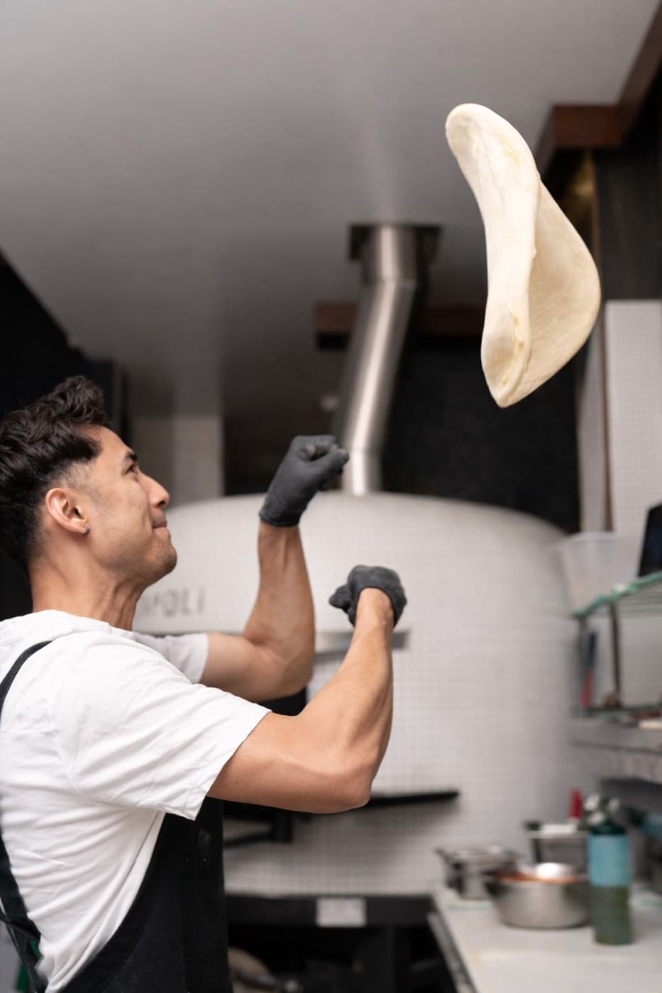 A chef sliding a pizza into the oven